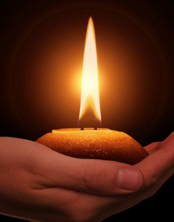 Vela encendida en una mano, símbolo de esperanza y autonomía